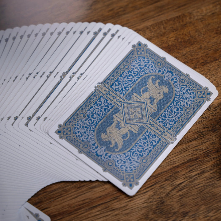 Eminence Blue Topaz playing cards with intricate design and a luxurious blue and gold color scheme