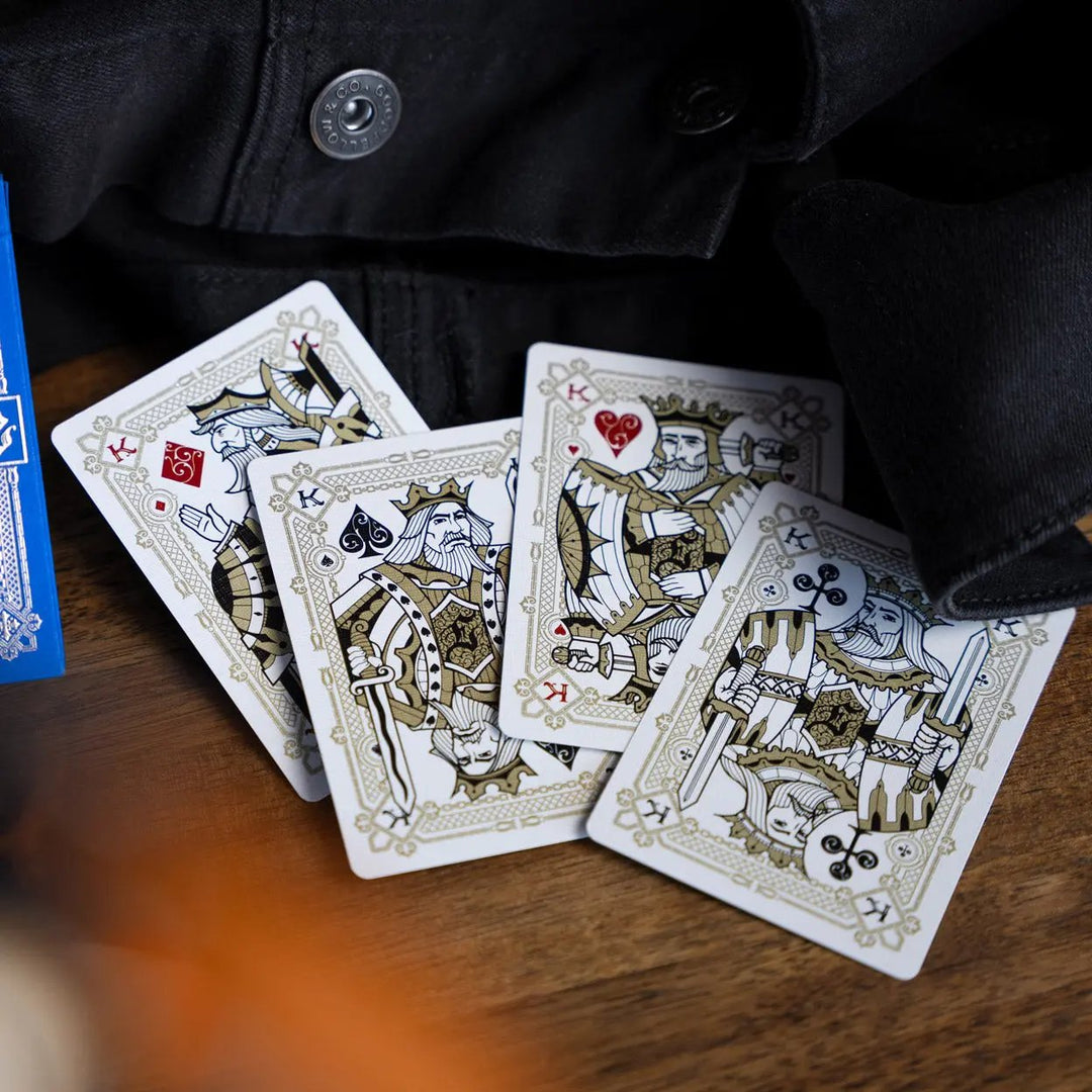 Eminence Blue Topaz playing cards featuring detailed king and queen designs on a wooden table