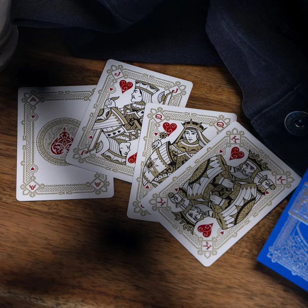 Eminence Blue Topaz playing cards featuring intricate designs and classic face cards on a wooden surface