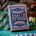 Apollo Blue playing cards in a stylish box surrounded by colorful poker chips