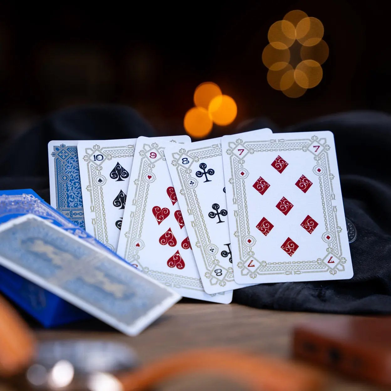 Eminence Blue Topaz playing cards featuring elegant designs with red and black suits displayed on a table