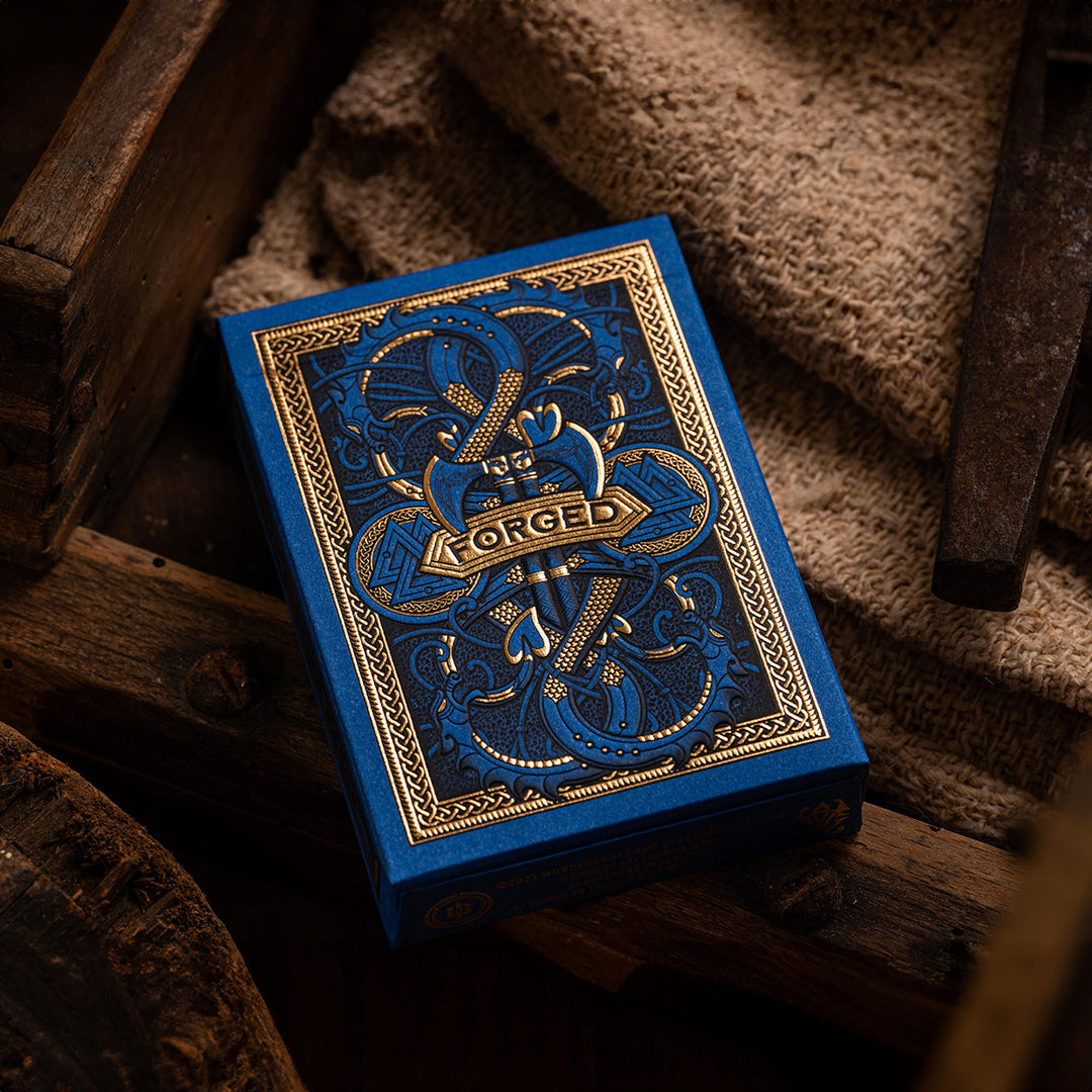 Forged Viking's Fury deck of playing cards with intricate blue and gold design on a wooden surface