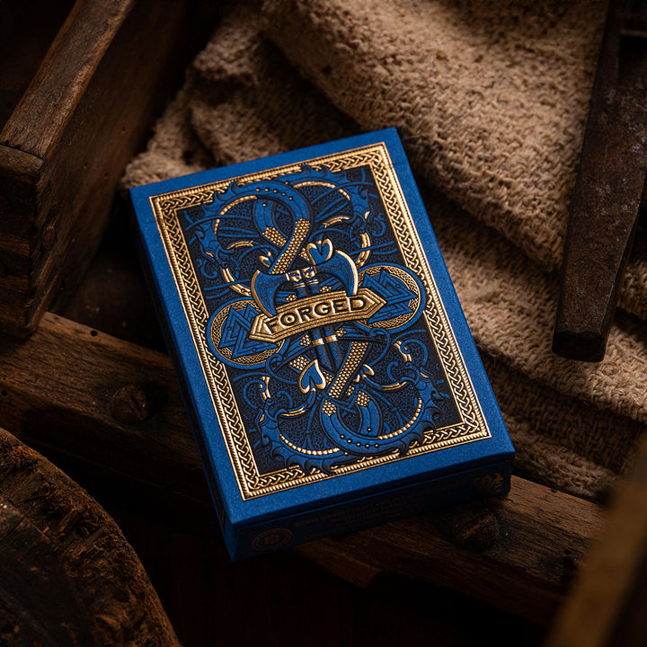 Forged Viking's Fury deck of playing cards with intricate blue and gold design on a wooden surface