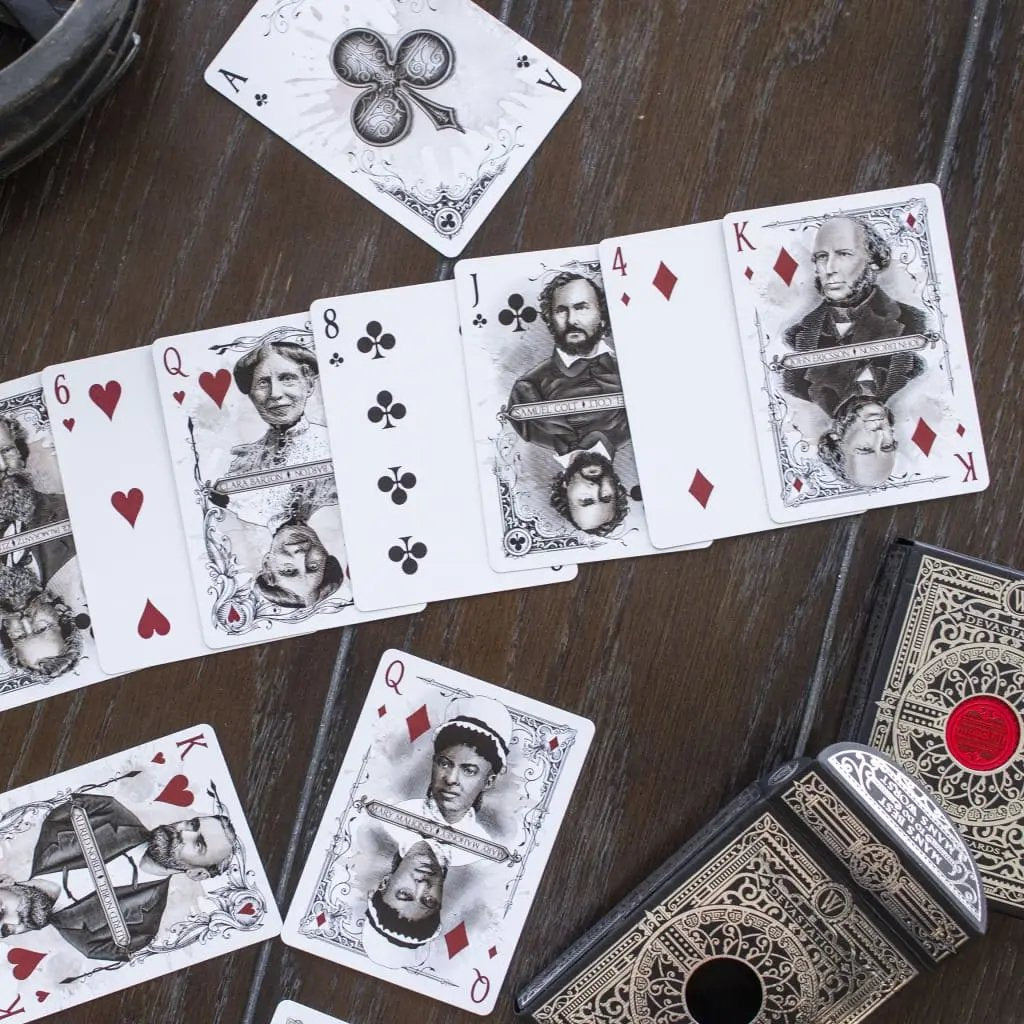 Devastation silver edition playing cards displayed on a wooden table with various face cards visible