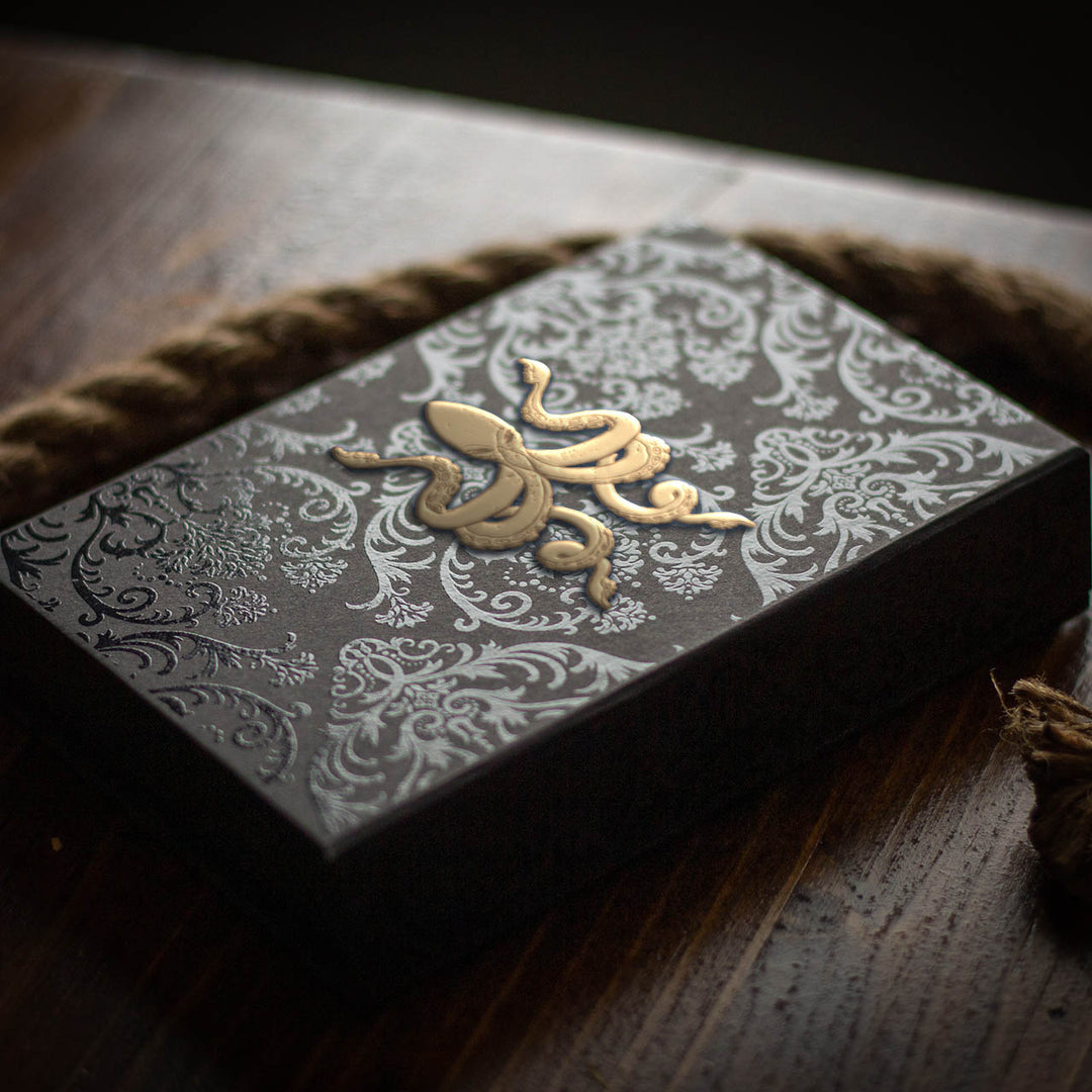 Kraken Signature playing card set in ornate black and gold packaging with intricate design